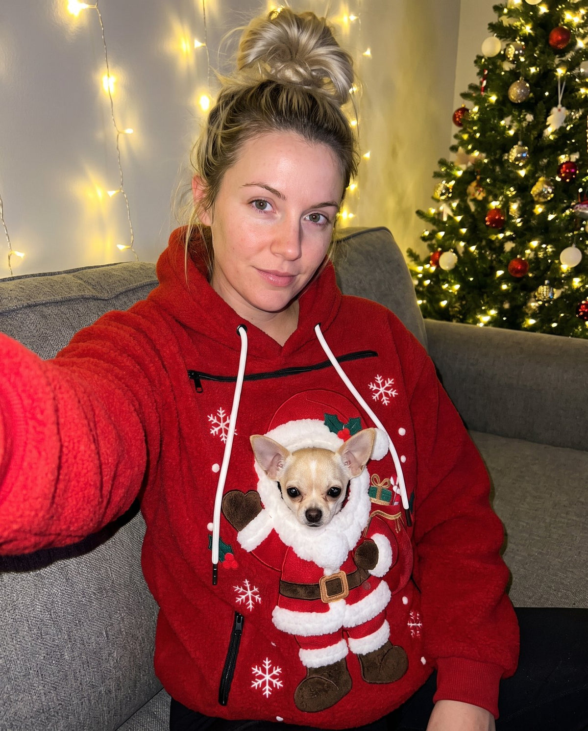 Customer selfie in the Santa pet pouch hoodie with a chihuahua by the Christmas tree